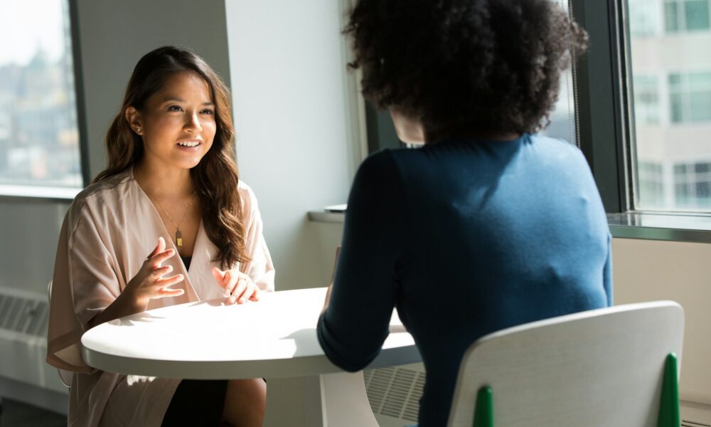 two women sitting on chair