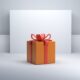 an orange gift box with a red bow