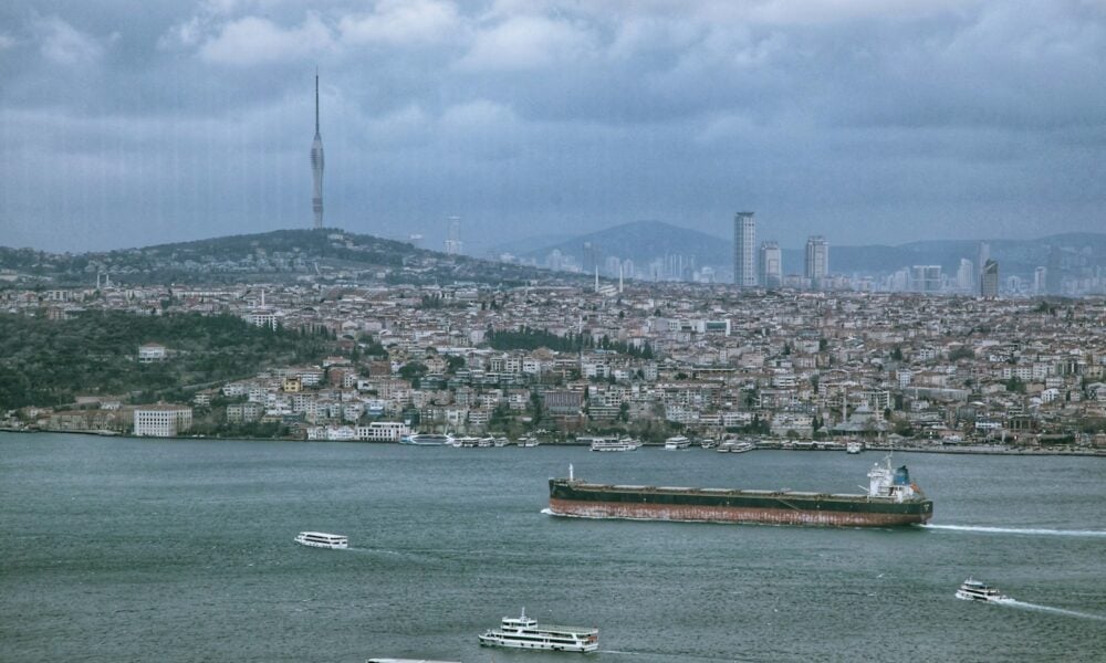 a large ship in the water with a city in the background