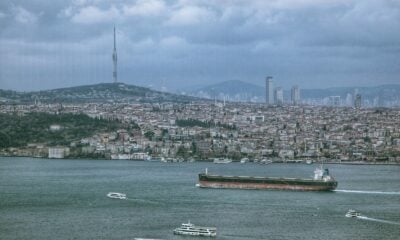 a large ship in the water with a city in the background
