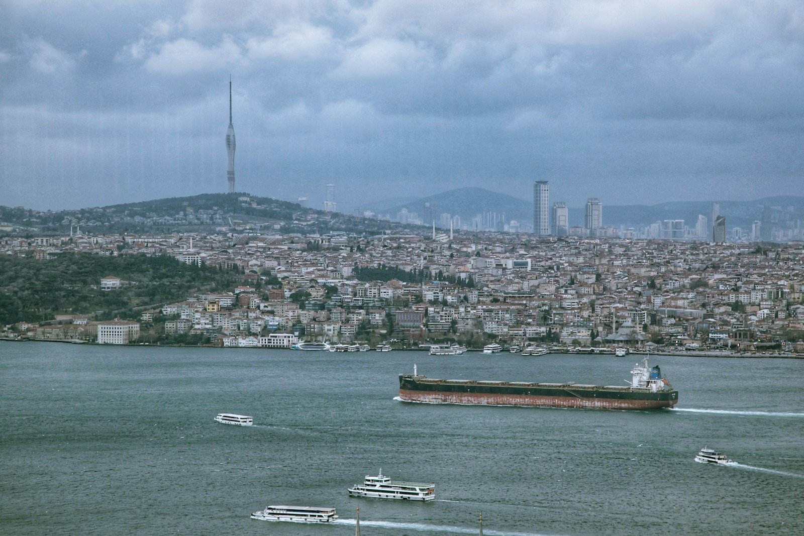 a large ship in the water with a city in the background