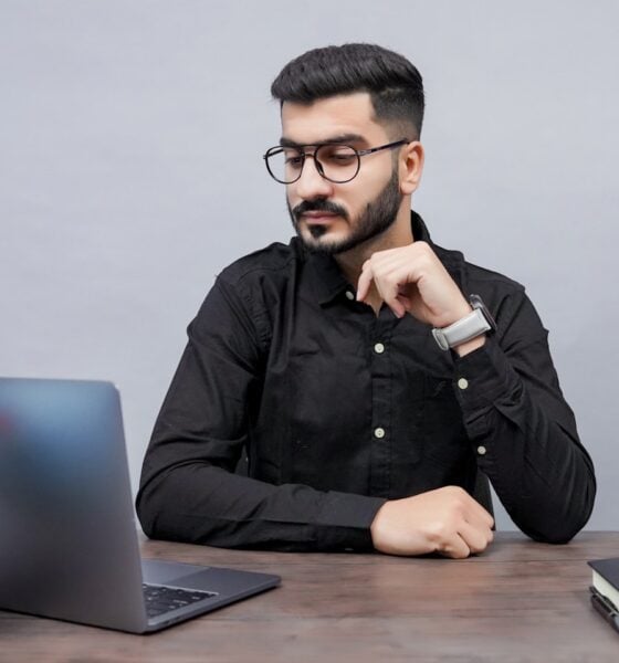 a man sitting at a desk with a laptop and a globe
