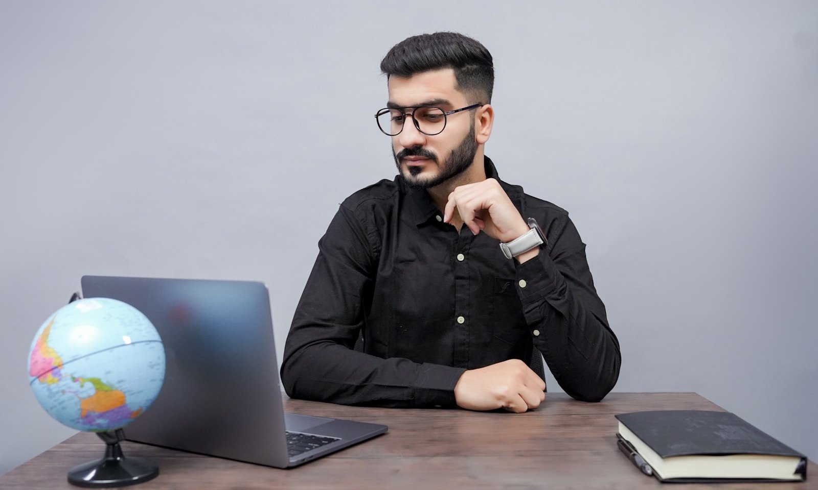 5 Key Lessons from the Founder of CouponzGuru for Aspiring Entrepreneurs 15 a man sitting at a desk with a laptop and a globe