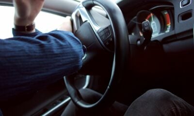 man holding black steering wheel
