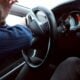 man holding black steering wheel