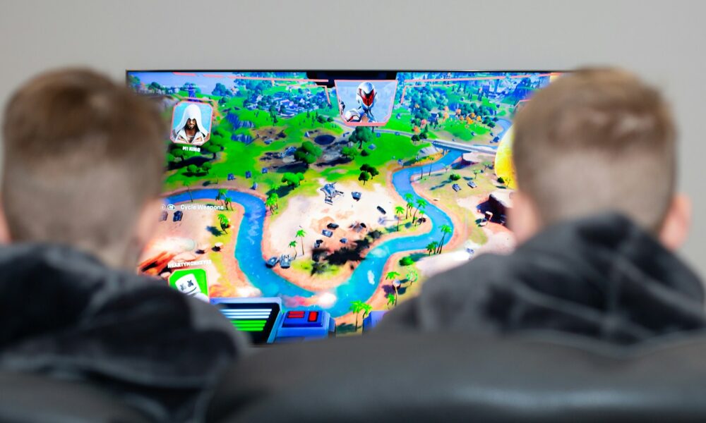 two boys are playing a video game on the television