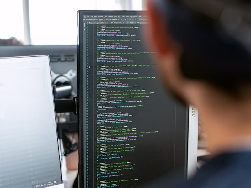 man in black shirt sitting in front of computer monitor