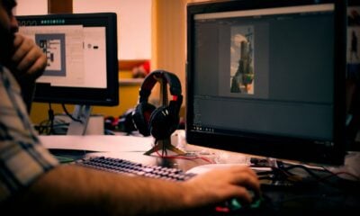 person holding mouse in front of monitor