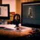 person holding mouse in front of monitor