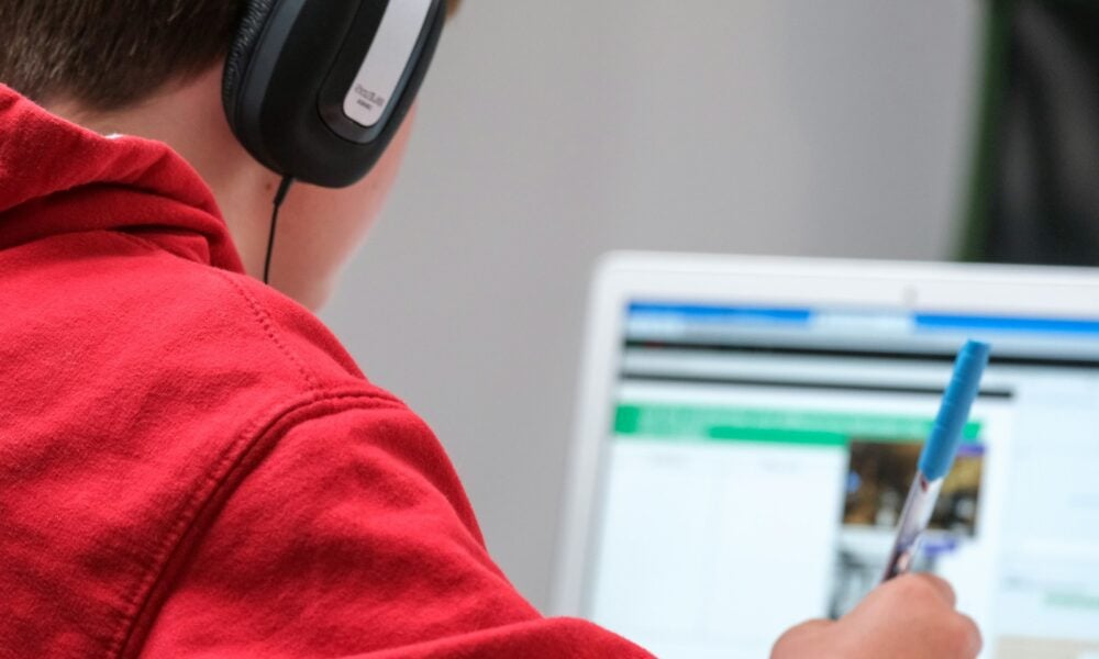person in red shirt wearing black and gray headphones