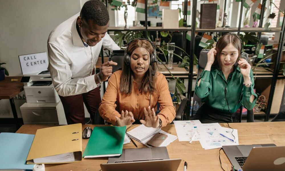A diverse group of call center employees collaborating in a modern office setting with teamwork and technology.