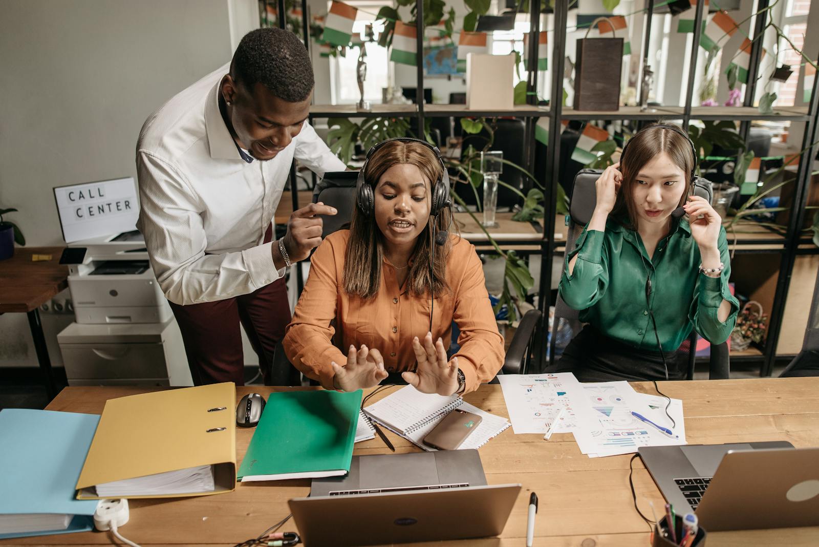A diverse group of call center employees collaborating in a modern office setting with teamwork and technology.