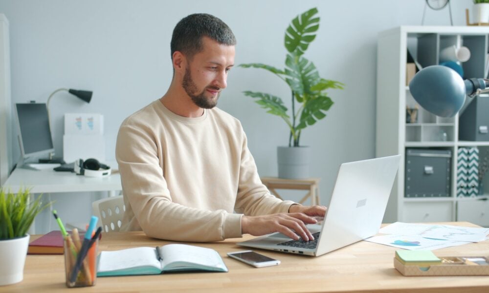 Man typing on laptop at a desk