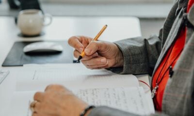 a person sitting at a desk writing on a piece of paper