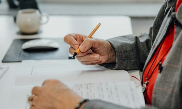 a person sitting at a desk writing on a piece of paper