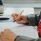 a person sitting at a desk writing on a piece of paper