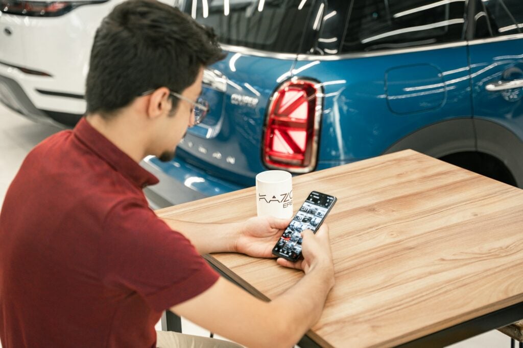 a man sitting at a table holding a cell phone