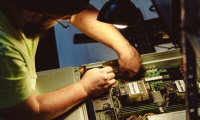 Man repairing a computer server under a lamp.