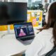 a woman sitting in front of a computer monitor