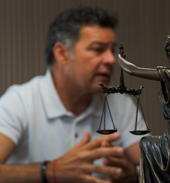 A man sitting at a table in front of a statue