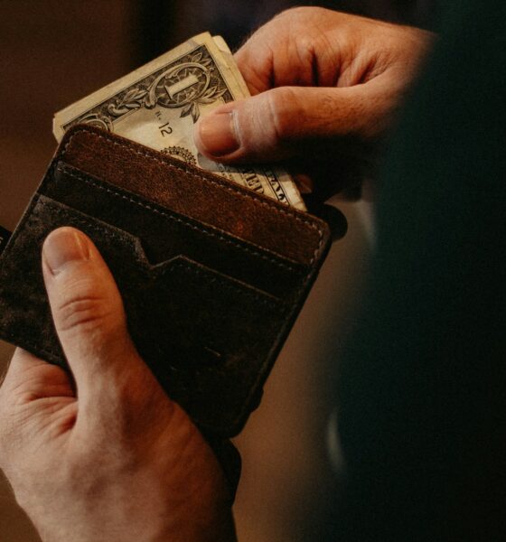 person getting 1 U.S. dollar banknote in wallet