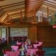 Restaurant interior with red chairs and wooden beams.
