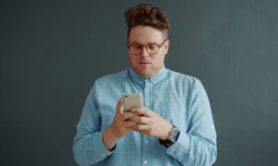 Man in glasses looking at his phone.