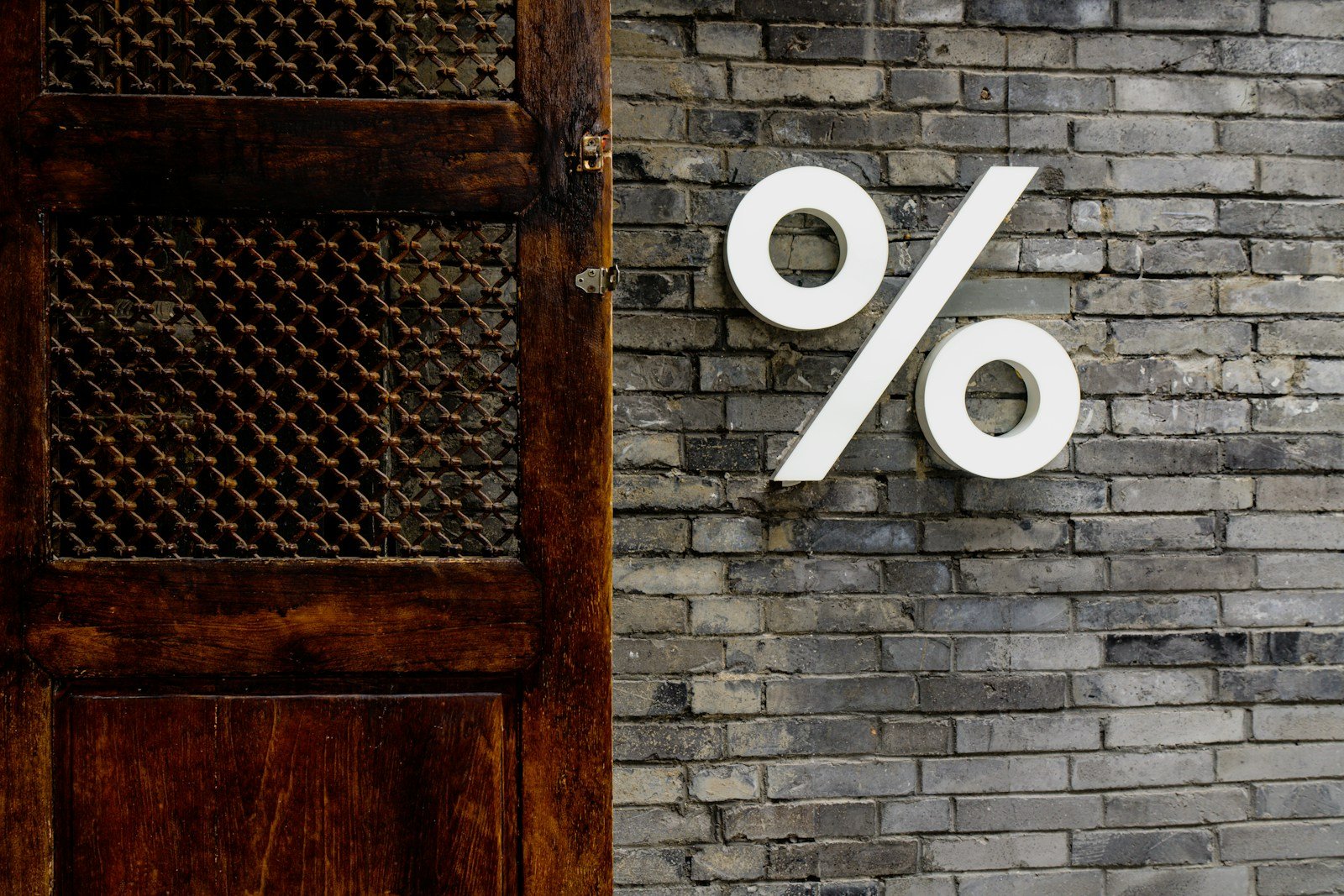 White percentage sign on a brick wall