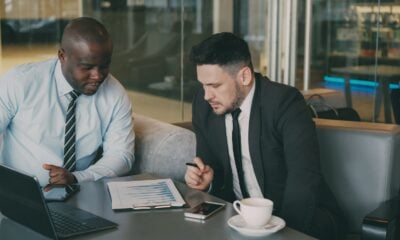 Two businessmen reviewing documents at a table.