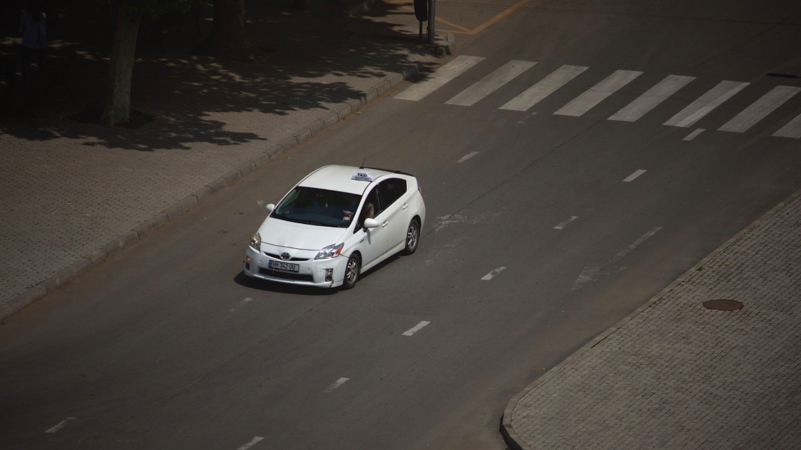 Is the 2024 Prius Truly Revolutionizing Hybrids? 15 A white car driving down a street next to a tree