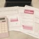Bills, calculator, and a laptop: financial tasks underway.