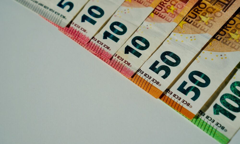 a row of ten hundred dollar bills sitting on top of a table