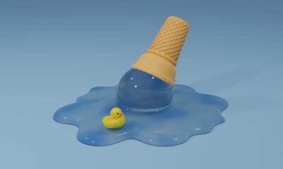 an ice cream cone with a rubber rubber duck floating on a puddle of blue water