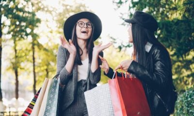 Two women with shopping bags in a park