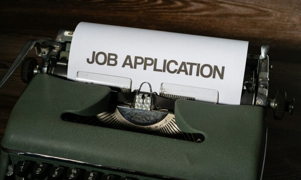 a typewriter with a job application printed on it