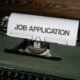 a typewriter with a job application printed on it