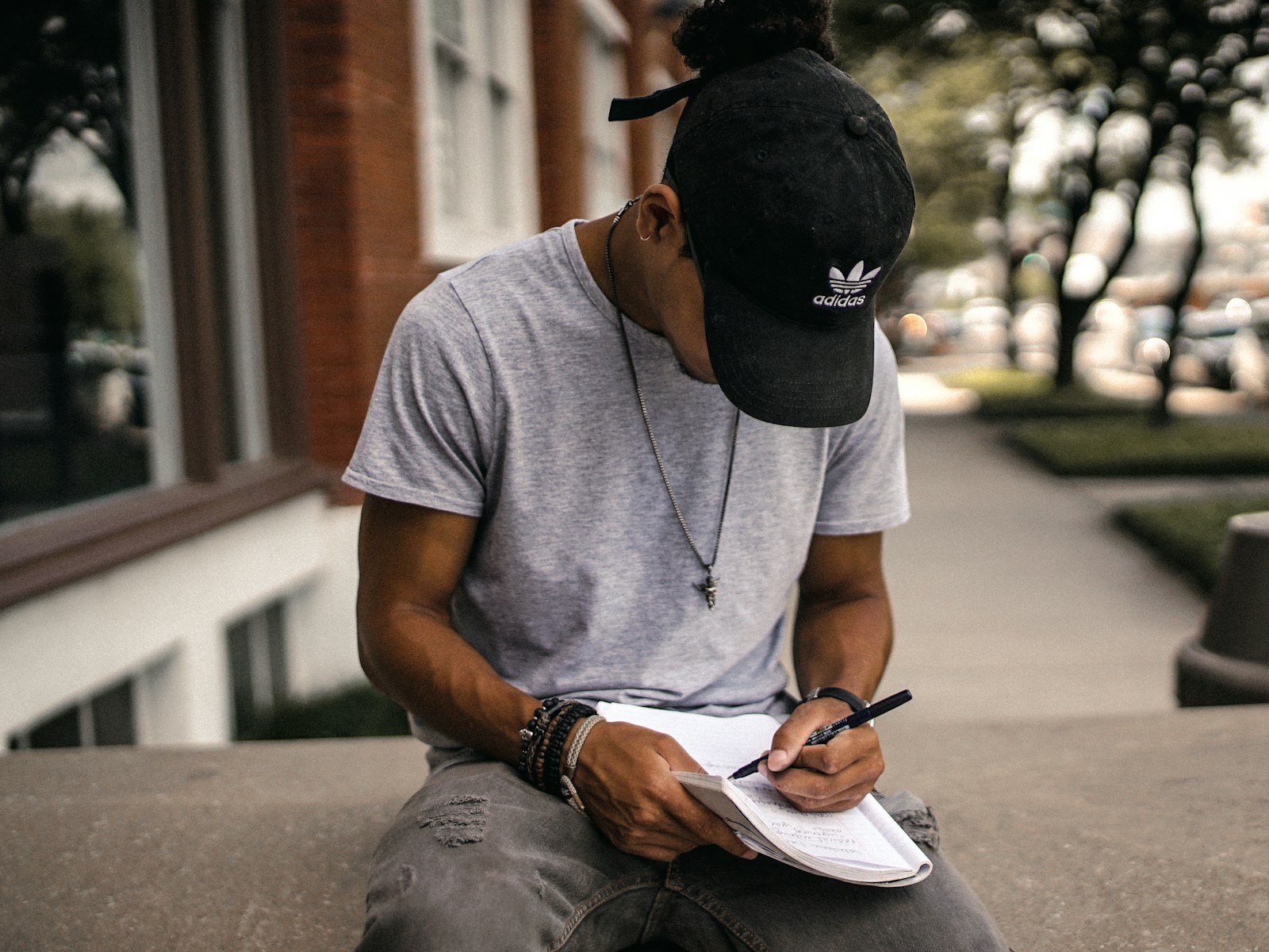 Understanding Disguised Unemployment: An Overview 15 person in black adidas cap sitting on bench writing on notebook