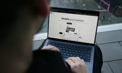 A man sitting on a bench using a laptop computer