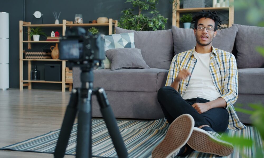 Man recording himself with a camera at home