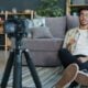 Man recording himself with a camera at home