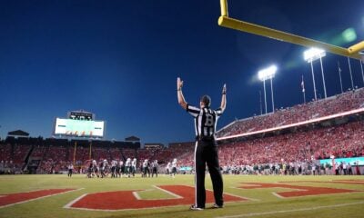 a football player standing on a field with his arms in the air