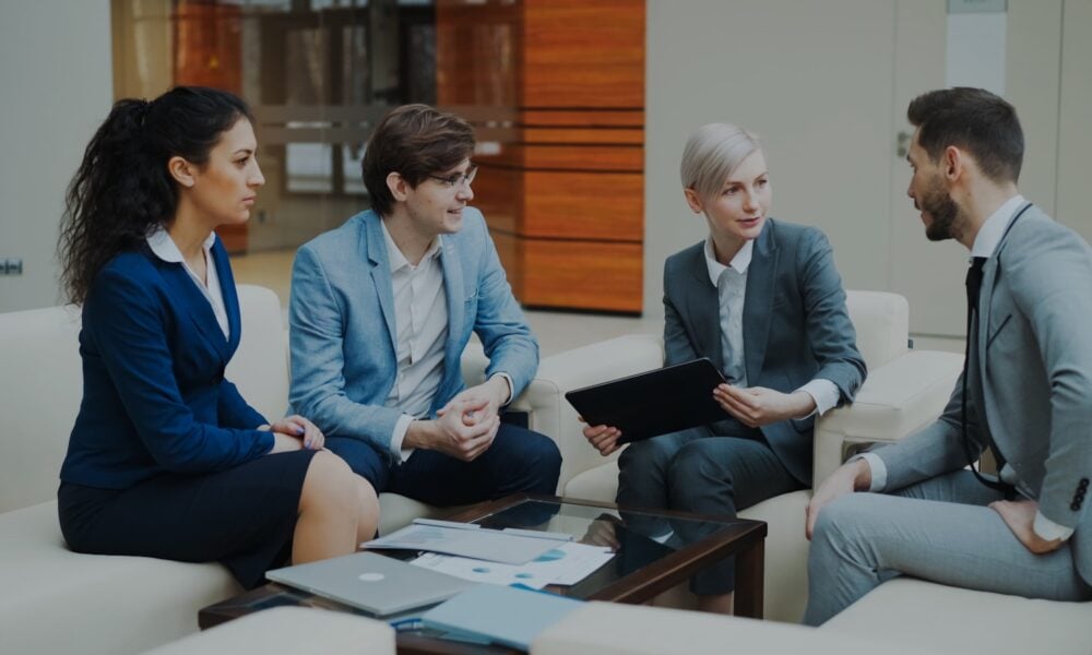 Four business people in a meeting discussing documents.