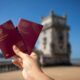 Holding two portuguese passports with a tower.