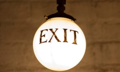 closeup photography of white hanging bulb light with exit signage