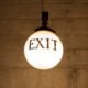 closeup photography of white hanging bulb light with exit signage