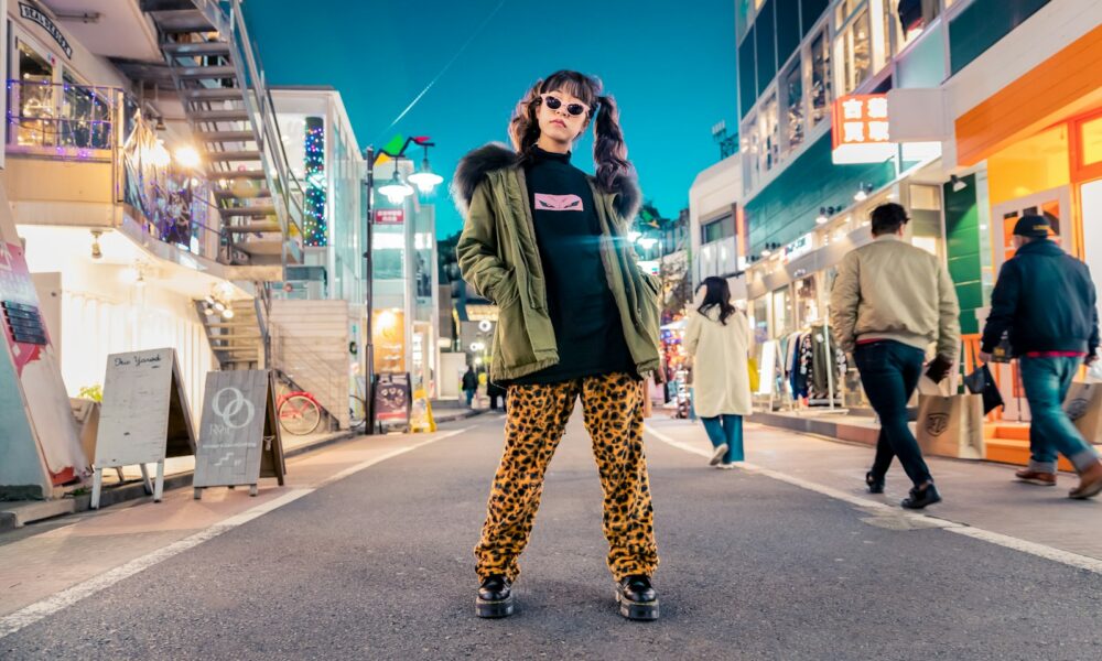 woman in green jacket stands and pose on street
