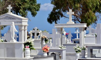 a bunch of white graves with flowers on them