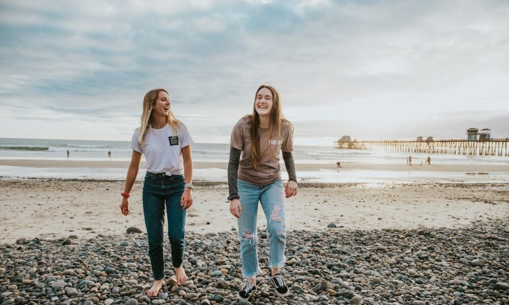 two women walking on pebbles