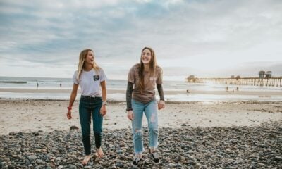 two women walking on pebbles