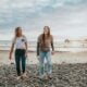 two women walking on pebbles